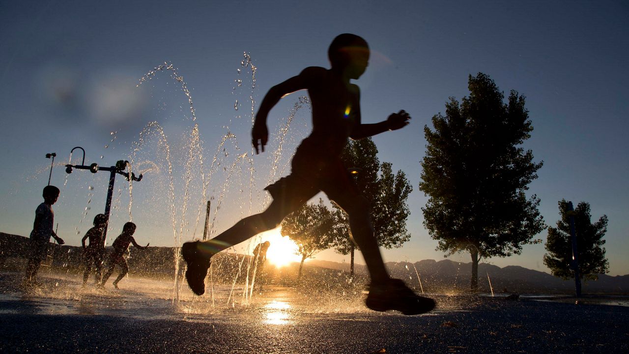 Kid running through sprinkler