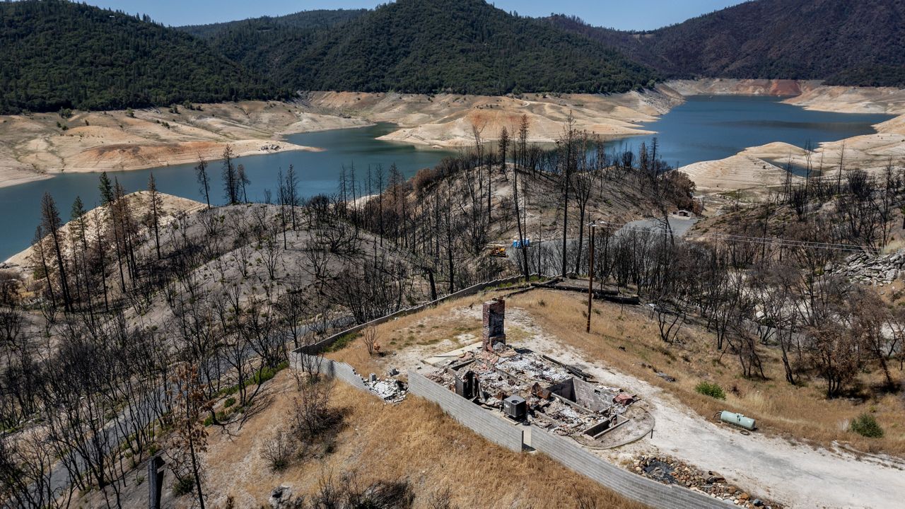 A home destroyed in the 2020 North Complex Fire sits above Lake Oroville, in Oroville, Calif. on May 23, 2021. (AP Photo/Noah Berger, File)