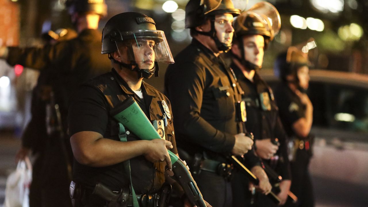 Police officers stand guard near City Hall during a protest after the Nov. 3 elections, Friday, Nov. 6, 2020, in Los Angeles. (AP Photo/Ringo H.W. Chiu)