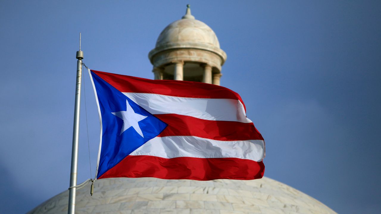 In this file photo from July 29, 2015, the Puerto Rican flag flies in front of the Capitol in San Juan, Puerto Rico. (Ricardo Arduengo/AP)
