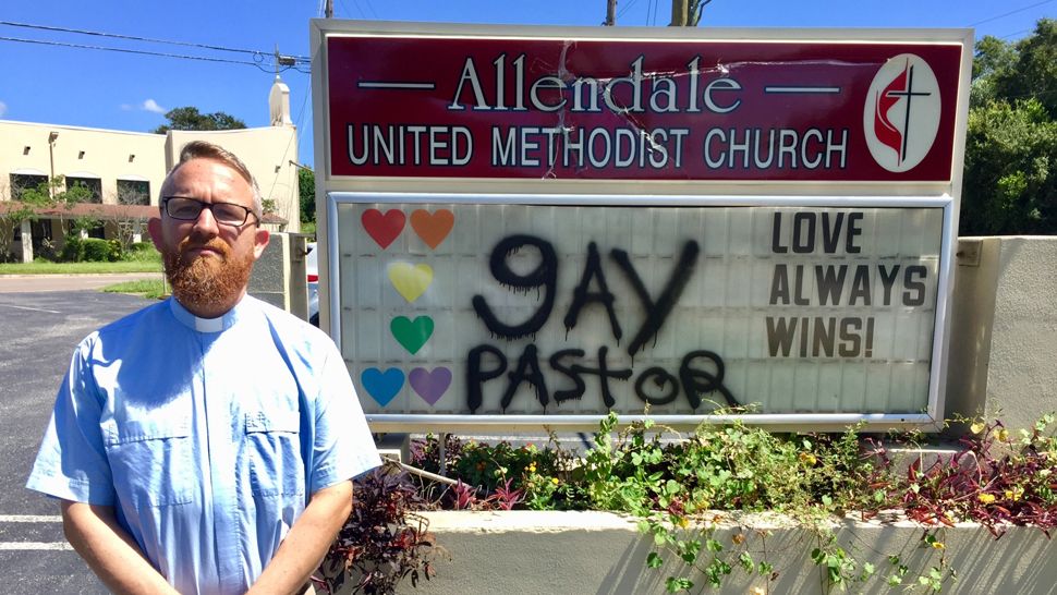 Pastor Andy Oliver of Allendale United Methodist Church, standing alongside a sign outside his church that was vandalized overnight, Monday, September 24, 2018. (Josh Rojas, staff)
