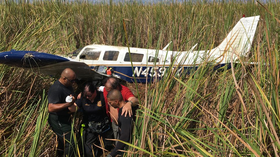 Polk deputies Aaron Motta (left) and Justin Salas (right) assist William Gonzalez, Jr., 70, from the plane he was piloting, which crashed in very shallow water near Lake Hancock on Friday, September 28, 2018. (Polk County Sheriff's Offce)