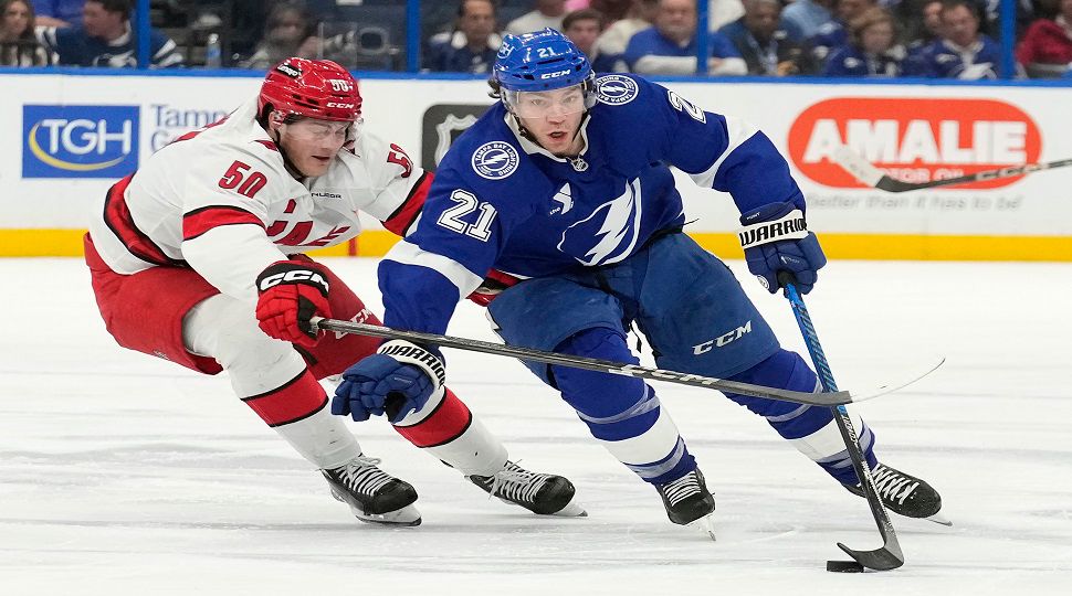 Tampa Bay Lightning center Brayden Point (21) cuts around Carolina Hurricanes left wing Eric Robinson (50) during the second period of an NHL hockey game Tuesday, Jan. 7, 2025, in Tampa, Fla. (AP Photo/Chris O'Meara)