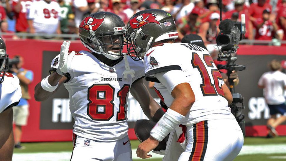 Tampa Bay Buccaneers wide receiver Antonio Brown (81) celebrates his 62-yard touchdown reception with quarterback Tom Brady (12) during the first half of the Bucs' 45-17 victory over the Dolphins. (AP Photo/Mark LoMoglio)