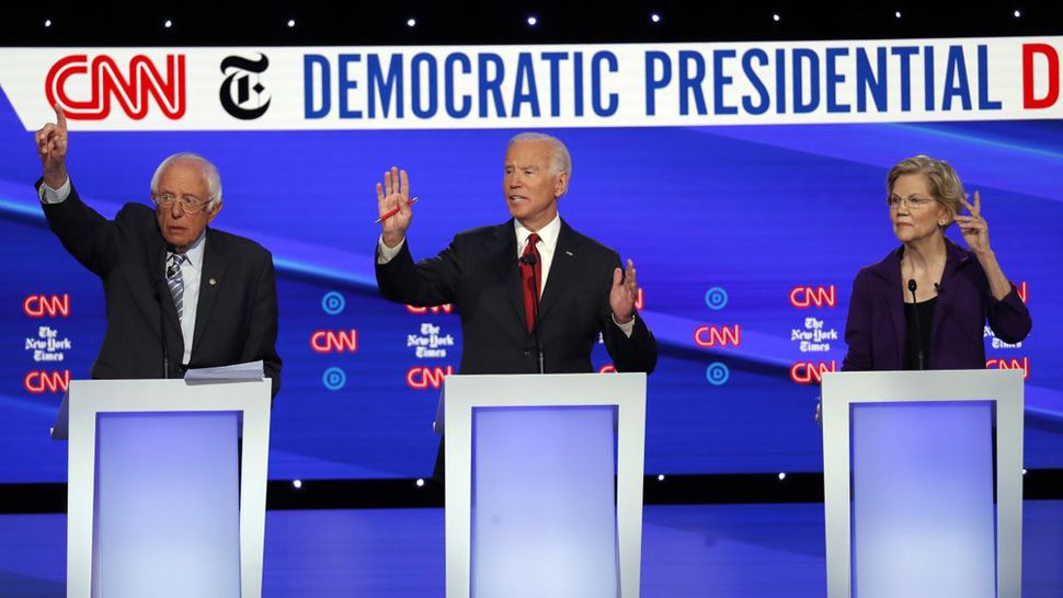 Democratic presidential candidate Sen. Bernie Sanders, I-Vt., left, former Vice President Joe Biden, center, and Sen. Elizabeth Warren, D-Mass., raise their hands to speak during a Democratic presidential primary debate hosted by CNN/New York Times at Otterbein University, Tuesday, Oct. 15, 2019, in Westerville, Ohio. (AP Photo/John Minchillo)