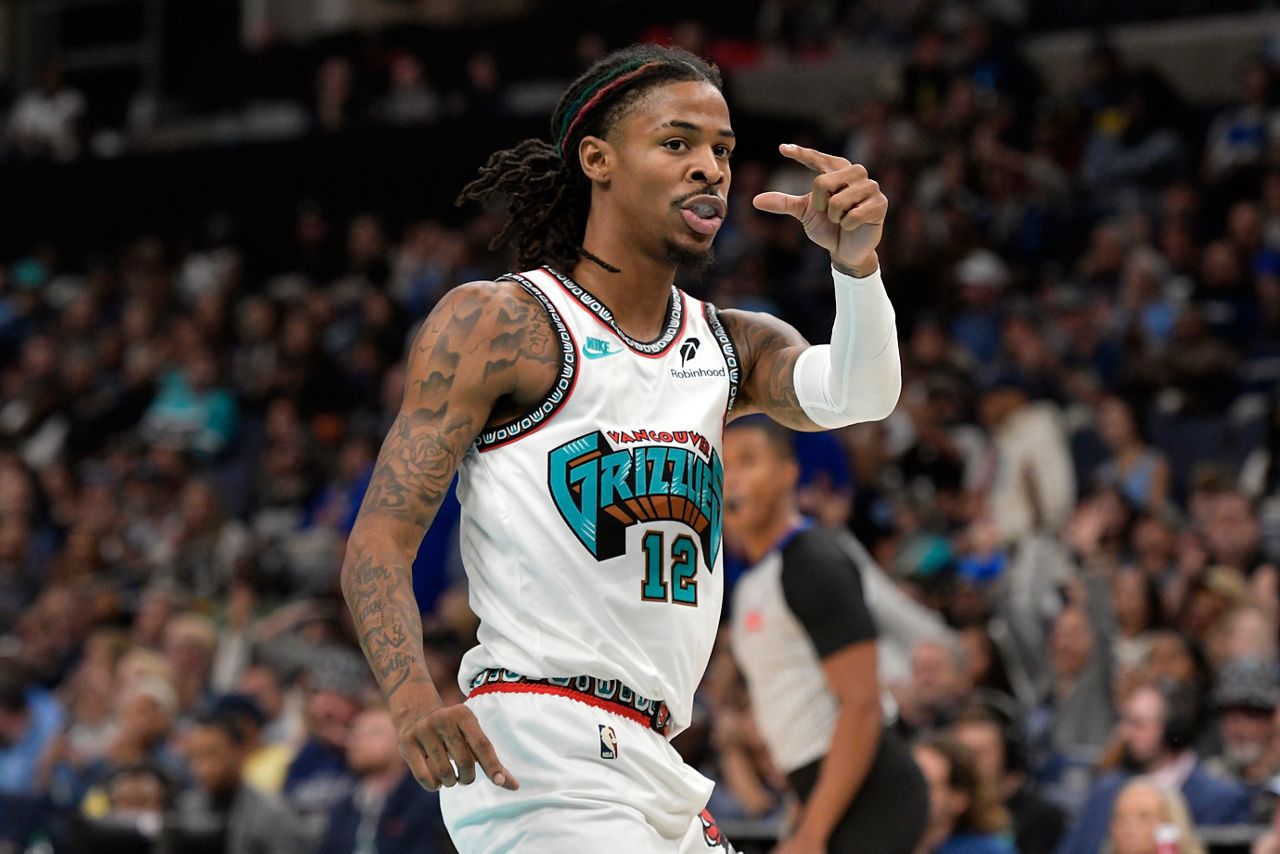 Memphis Grizzlies guard Ja Morant (12) gestures to Orlando Magic players in the first half of an NBA basketball game Saturday, Oct. 26, 2024, in Memphis, Tenn. (AP Photo/Brandon Dill)