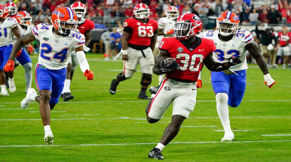 Georgia running back Daijun Edwards (30) runs for a 22-yard touchdown past Florida cornerback Avery Helm (24) and defensive lineman Princely Umanmielen (33) in last year's meeting in Jacksonville. (AP Photo/John Raoux)