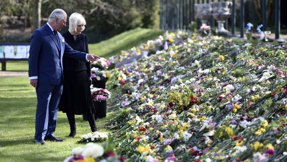 Britain's Prince Charles and Camilla, Duchess of Cornwall visit the gardens of Marlborough House, London, Thursday April 15, 2021, to look at the flowers and messages left by members of the public outside Buckingham Palace, following the death of Prince Philip. (Jeremy Selwyn/Pool via AP)