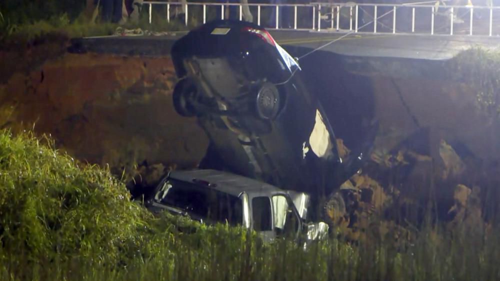 In this image made from video and provided by WLOX-TV, a vehicle is extracted from a hole on highway 26, Tuesday, Aug. 31, 2021, near Lucedale, Miss. (WLOX-TV via AP)