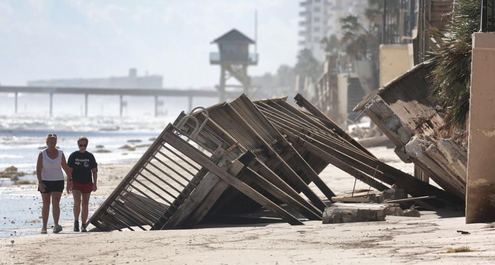Beachgoers survey the damage in Daytona Beach Shores, Fla., as hotel and condo seawalls and pool decks along the Volusia County coastline were gutted by Hurricane Ian last week. (Joe Burbank/Orlando Sentinel via AP)