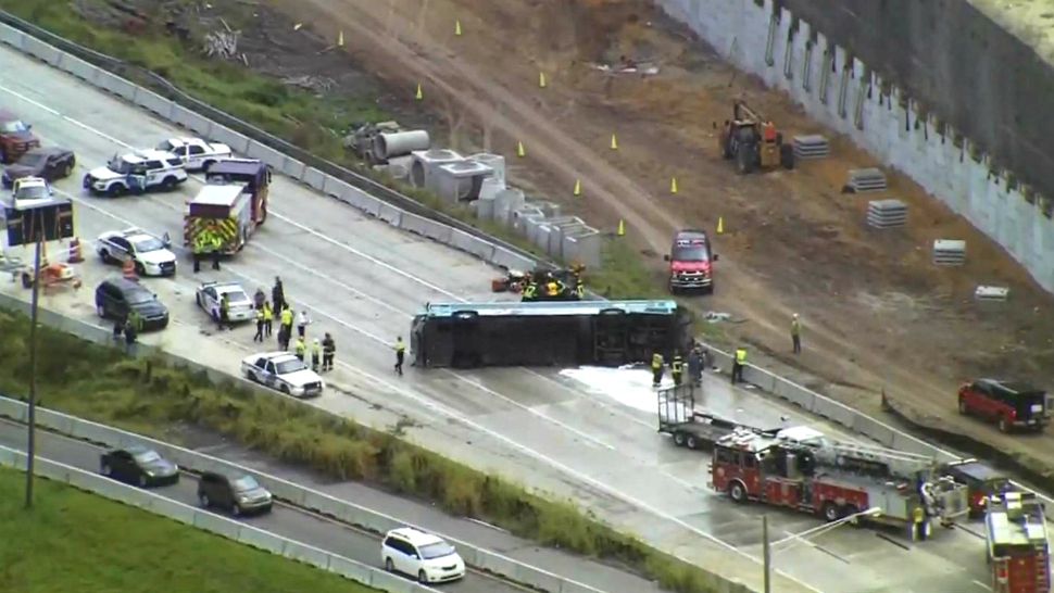 A Lynx bus sits on its side on Interstate 4 on Tuesday afternoon. (Sky 13)