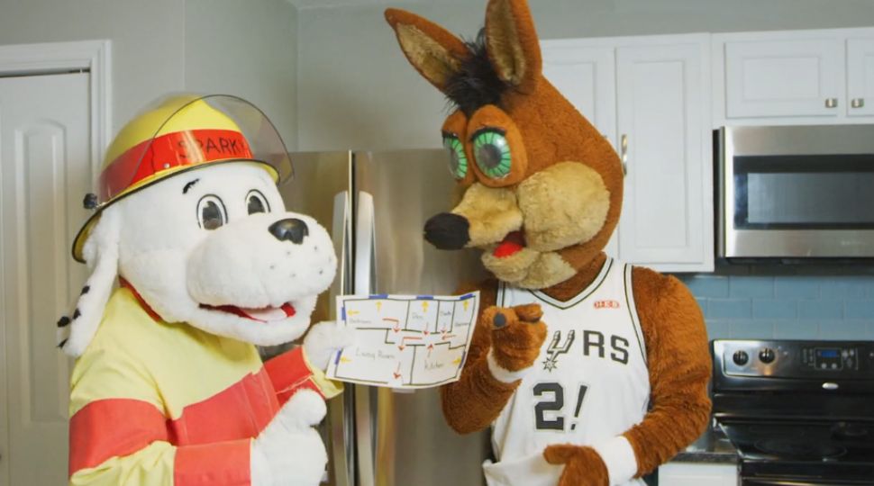 The San Antonio Fire Department's Sparky the Fire Dog and Spurs' mascot The Coyote hold a fire escape plan inside of kitchen (Courtesy: SAFD)