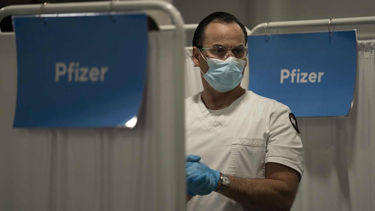 Student nurse Dario Gomez pauses for a moment while administering the Pfizer COVID-19 vaccine to patients at Providence Edwards Lifesciences vaccination site in Santa Ana, Calif., Friday, May 21, 2021. (AP Photo/Jae C. Hong)