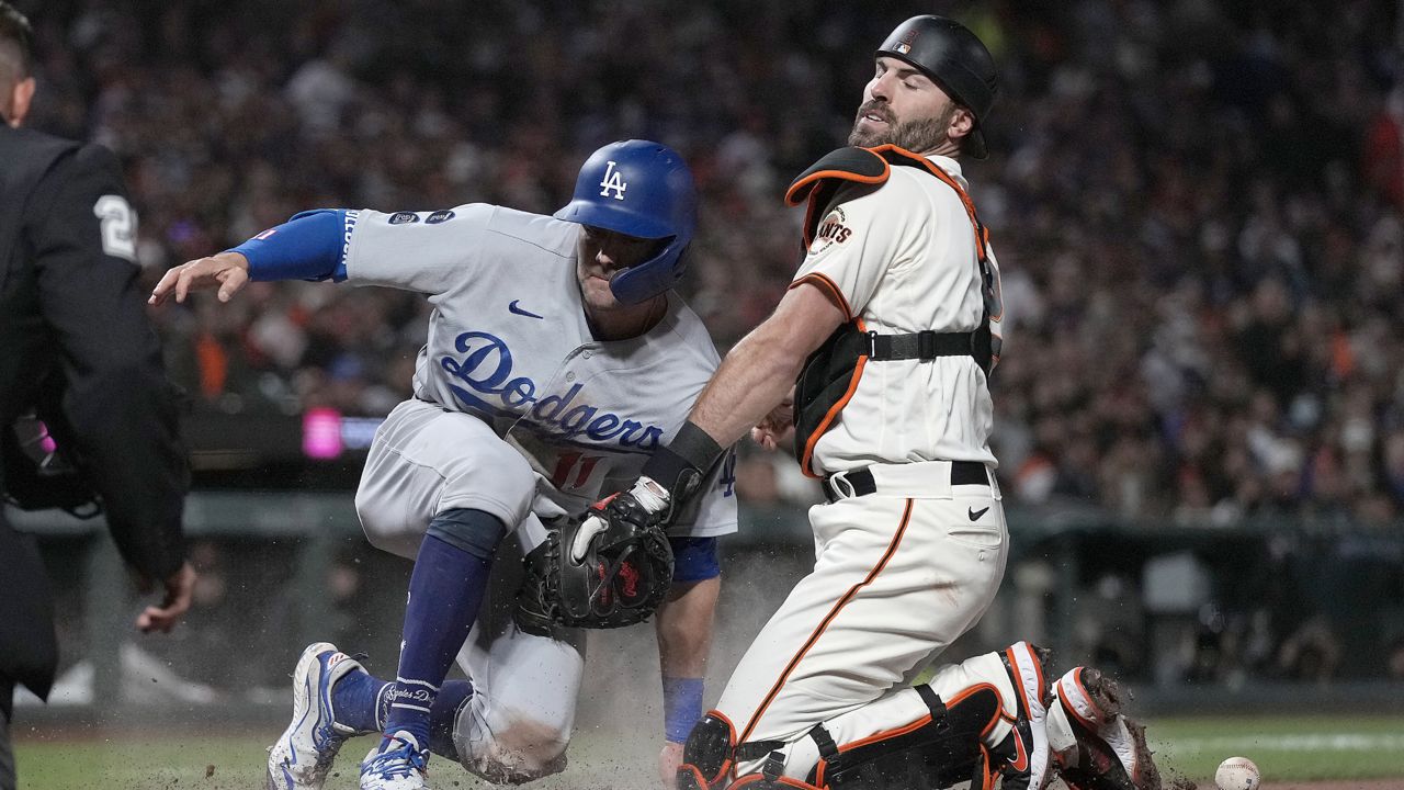 Los Angeles Dodgers' AJ Pollock, left, scores a run as San Francisco Giants catcher Curt Casali drops the ball during the seventh inning of a baseball game Wednesday, July 28, 2021, in San Francisco. (AP Photo/Tony Avelar)