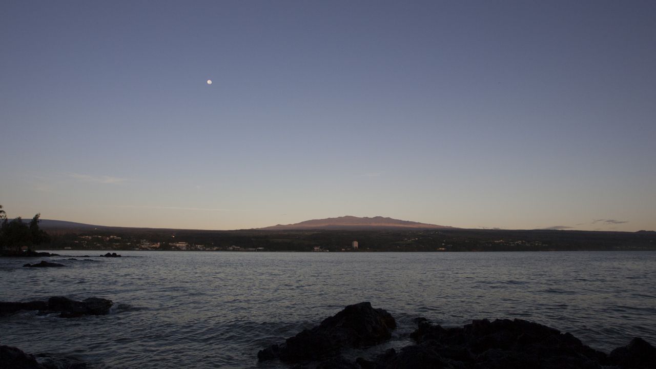 The moon sets over the Big Island’s Mauna Kea, Monday, Aug. 31, 2015, in Hilo, Hawaii. (AP Photo/Caleb Jones)