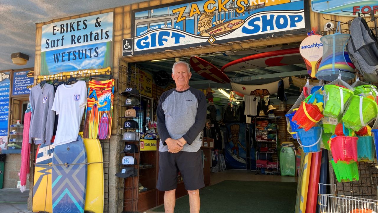 Mike Ali, the owner of Zack's shop near the Huntington Beach pier, waits for customers in Huntington Beach, Calif., Sunday. Oct. 10, 2021. (AP Photo/Amy Taxin)