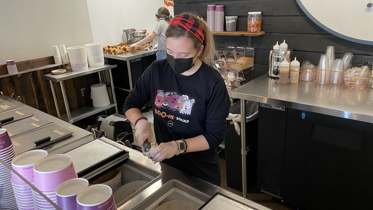 Tory Stephenson, an employee at Crank & Boom's Clays Mill Road location, serves a scoop of ice cream. Crank & Boom began as an idea to offer a dessert to pair with Thai food and has grown to have two Lexington locations and was named 2021 Small Business of the Year by Commerce Lexington. (Spectrum News 1/Brandon Roberts)