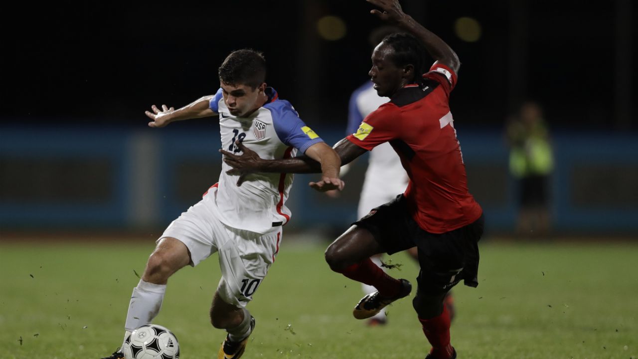United States' Christian Pulisic, left, fight for the ball with Trinidad and Tobago's Nathan Lewis during a 2018 World Cup qualifying soccer match in Couva, Trinidad, Tuesday, Oct. 10, 2017. (AP Photo/Rebecca Blackwell)
