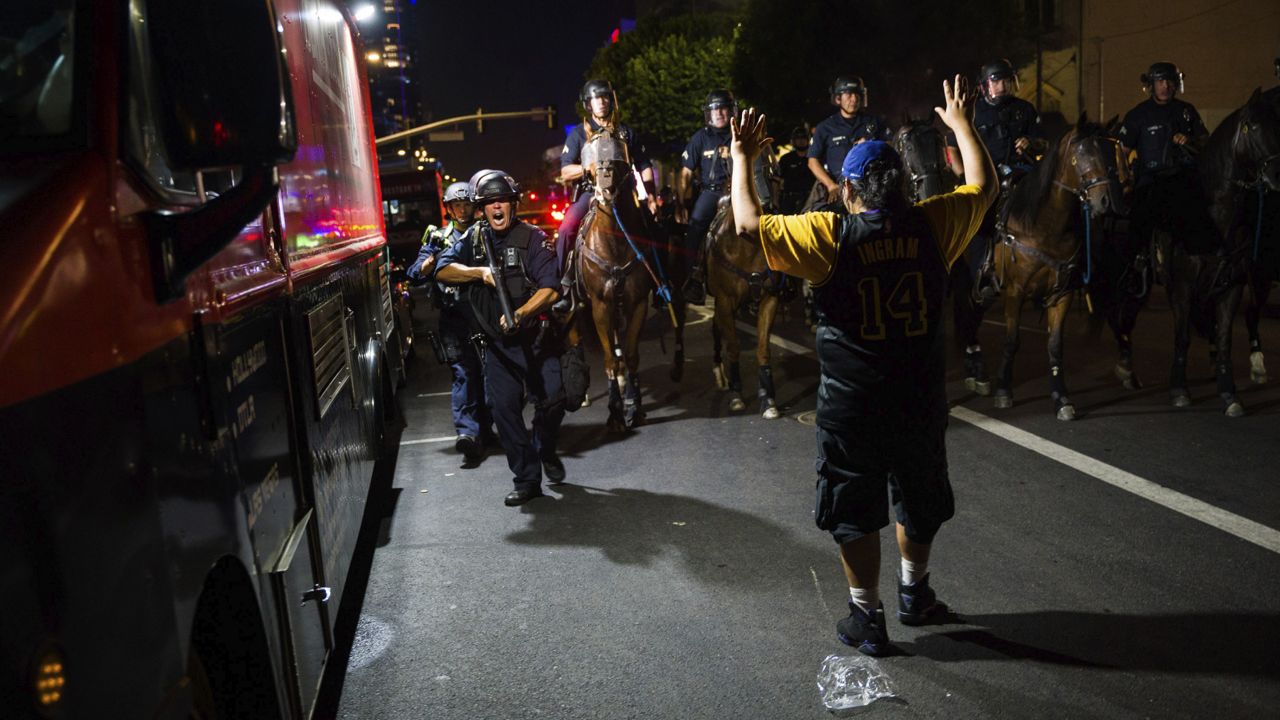 Los Angeles Police Department officers on horseback move people back as rowdy fans celebrate, Sunday, Oct. 11, 2020, in Los Angeles, after the Los Angeles Lakers defeated the Miami Heat in Game 6 of basketball's NBA Finals to win the championship. (AP Photo/Jintak Han)