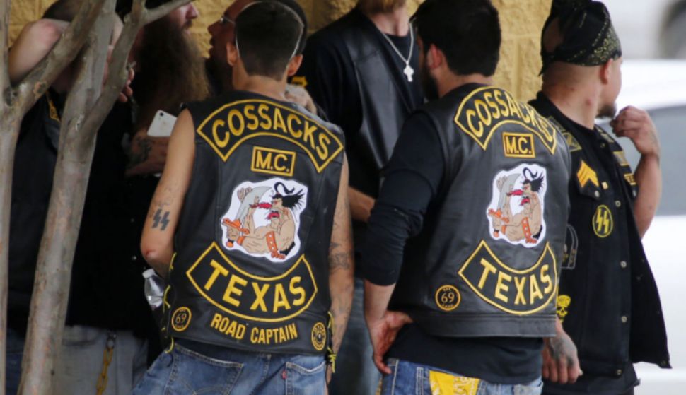 Bikers congregate against a wall while authorities investigate near a Twin Peaks restaurant Sunday, May 17, 2015, in Waco, Texas. A shootout there left nine dead, 18 injured and 170 bikers from both sides behind bars. (Rod Aydelotte/Waco Tribune-Herald via AP)