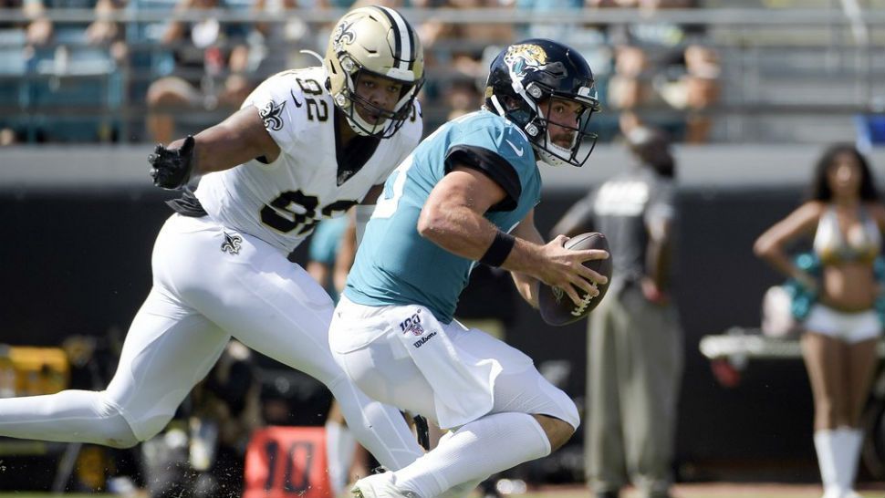 Jacksonville Jaguars quarterback Gardner Minshew, right, tries to scramble past New Orleans Saints defensive end Marcus Davenport (92) during the first half of an NFL football game, Sunday, Oct. 13, 2019, in Jacksonville, Fla. (AP Photo/Phelan M. Ebenhack)