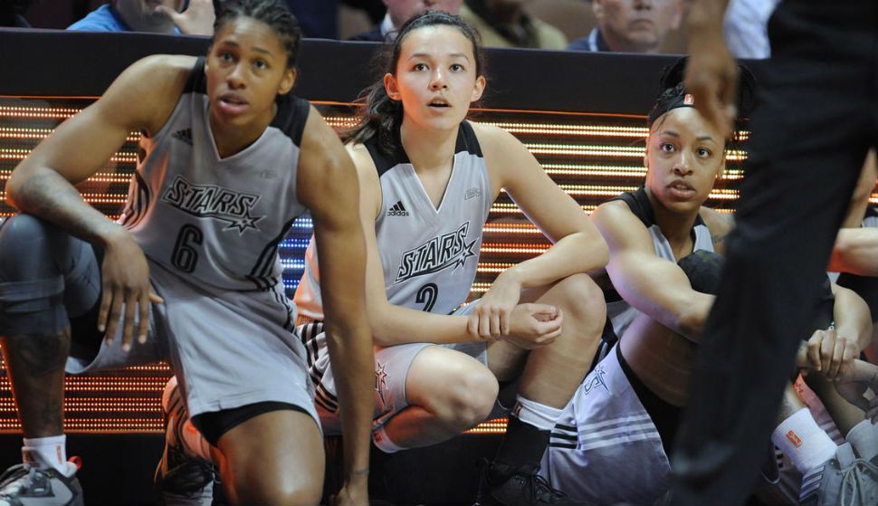 In this May 4, 2016 photo, San Antonio Stars' Kelsey Minato, center, waits with her teammate to come into play during the second half of a WNBA basketball game against the Atlanta Dream, in Uncasville, Conn. (AP Photo/Jessica Hill)