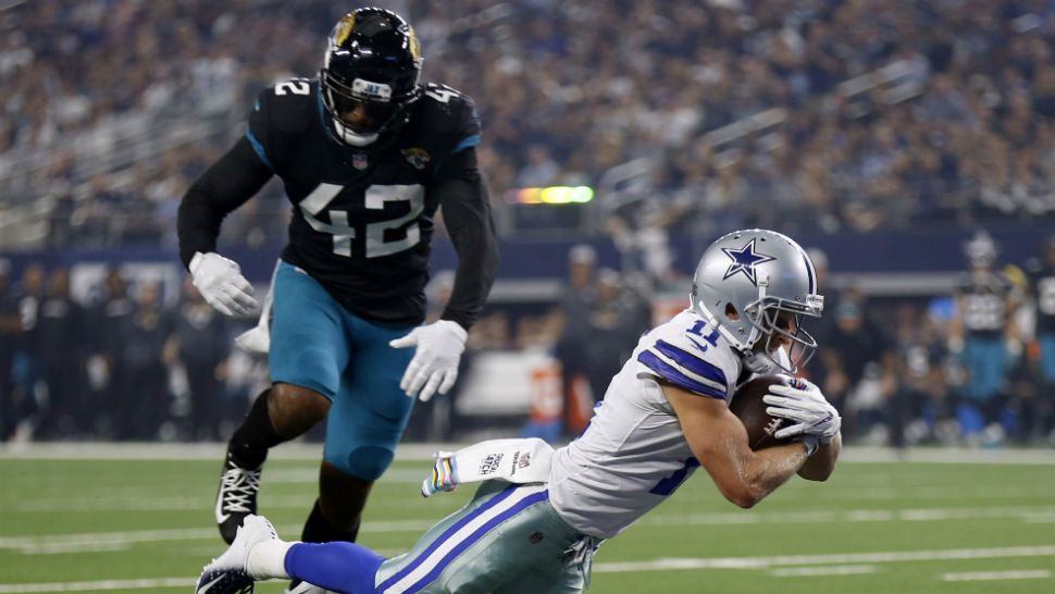 Dallas Cowboys wide receiver Cole Beasley (11) dives into the end zone in front of Jacksonville Jaguars strong safety Barry Church (42) for a touchdown in the first half of an NFL football game in Arlington, Texas, Sunday, Oct. 14, 2018. (AP Photo/Ron Jenkins)