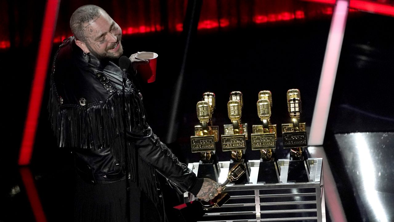 Post Malone appears on stage with his nine awards to include top male artist and top artist at the Billboard Music Awards on Wednesday, Oct. 14, 2020, at the Dolby Theatre in Los Angeles. (AP Photo/Chris Pizzello)