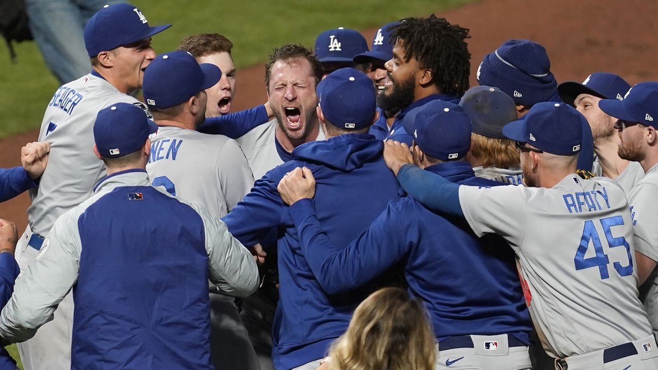 Los Angeles Dodgers pitcher Max Scherzer, center facing, celebrates with teammates after the Dodgers defeated the San Francisco Giants in Game 5 of a baseball National League Division Series Thursday, Oct. 14, 2021, in San Francisco. (AP Photo/Eric Risberg)
