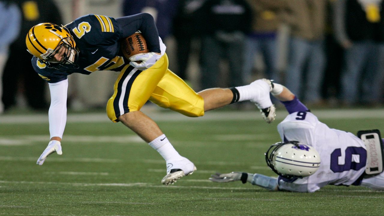 A football player runs away from a tackler