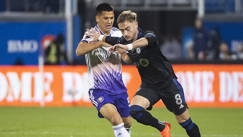 Orlando City SC's Cesar Araujo, left, challenges CF Montreal's Djordje Mihailovic during first-half MLS playoff soccer match action in Montreal, Sunday, Oct. 16, 2022. (Graham Hughes/The Canadian Press via AP)