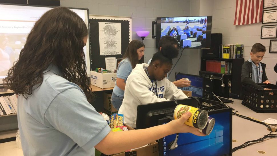 Almost a dozen students at Lee Middle School on Tuesday stacked crate after crate with non-perishable foods for Michael victims. (Lauren Verno, Spectrum Bay News 9)