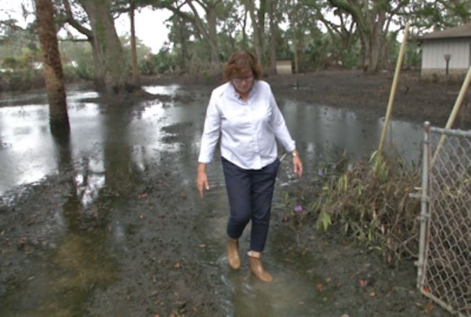 Karen Blaydes treks through the muck that was the yard of her home in Longwood. Floodwaters have receded and Blaydes is learning the sad truth about what's left behind. (Jeff Allen, Staff)