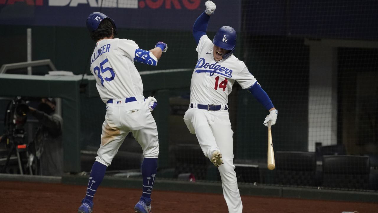 Los Angeles Dodgers' Cody Bellinger celebrates his home run with Enrique Hernández against the Atlanta Braves during the seventh inning in Game 7 of the NLCS Sunday, Oct. 18, 2020, in Arlington, Texas. (AP Photo/Tony Gutierrez)