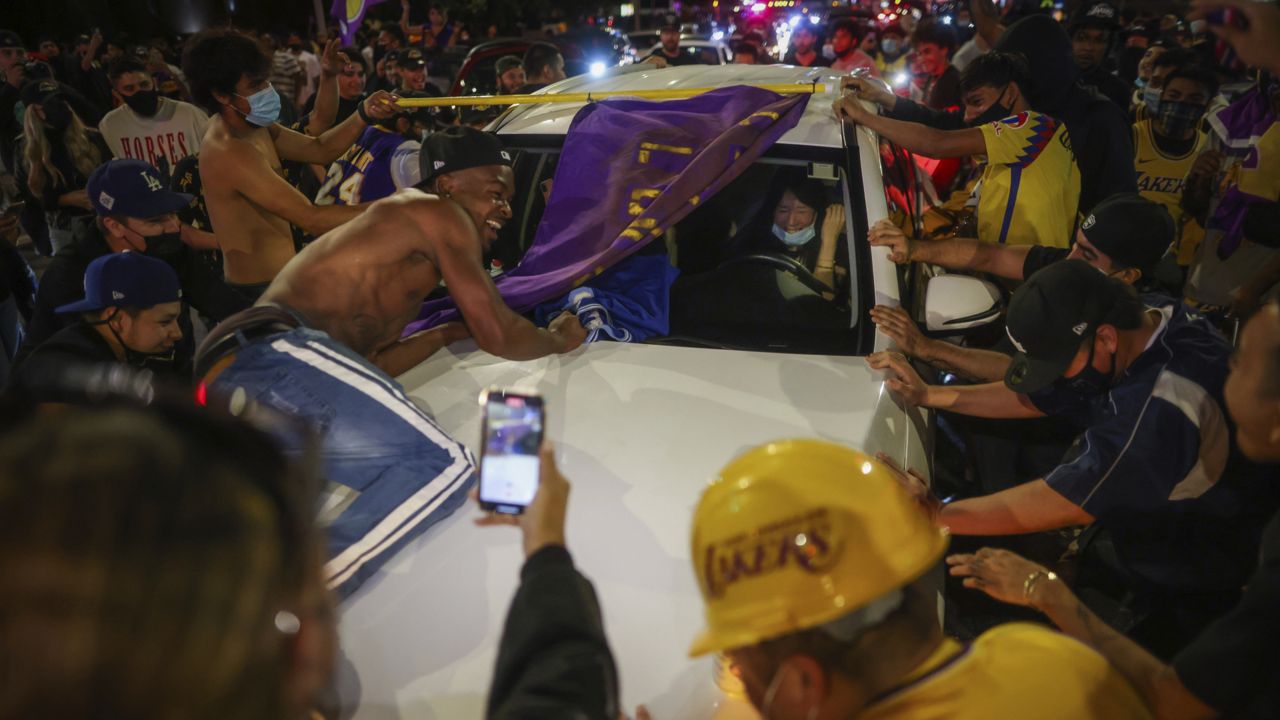 Lakers fans celebrate outside of Staples center Sunday, Oct. 11, 2020, in Los Angeles, Calif. (AP Photo/Christian Monterrosa)