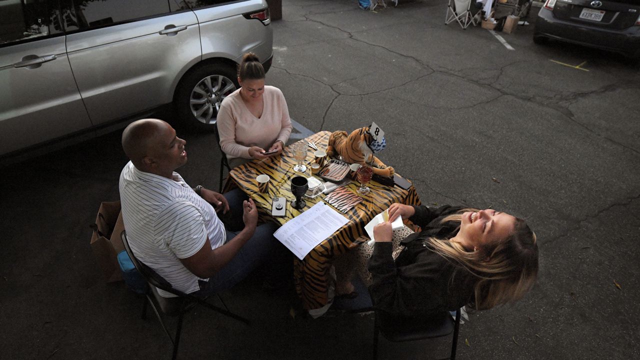 Customers at Vitello's are reserving parking spaces, bringing their own tables, and even fine china to enjoy an al fresco takeout meal on the asphalt outside the Italian restaurant. (AP Photo/Mark J. Terrill)