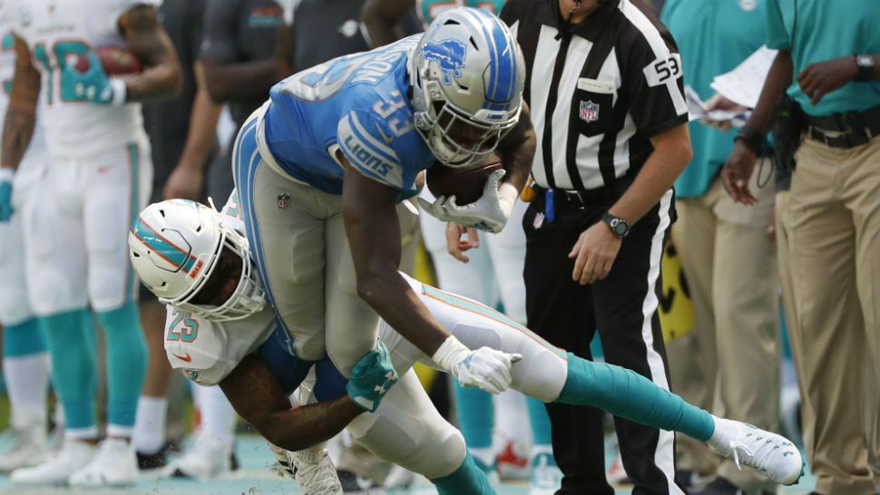 Miami Dolphins cornerback Xavien Howard (25) tackles Detroit Lions running back Kerryon Johnson (33), during the first half of an NFL football game, Sunday, Oct. 21, 2018, in Miami Gardens, Fla. (AP Photo/Wilfredo Lee)