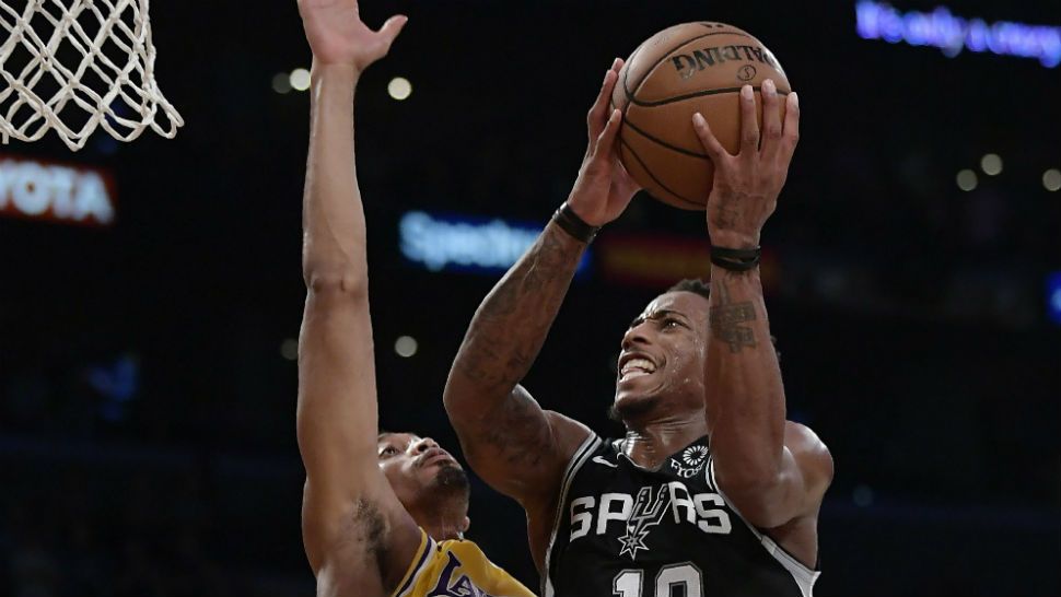 San Antonio Spurs guard DeMar DeRozan, right, shoots as Los Angeles Lakers forward Johnathan Williams defends during the second half of an NBA basketball game Monday, Oct. 22, 2018, in Los Angeles. The Spurs won 143-142. (AP Photo/Mark J. Terrill)