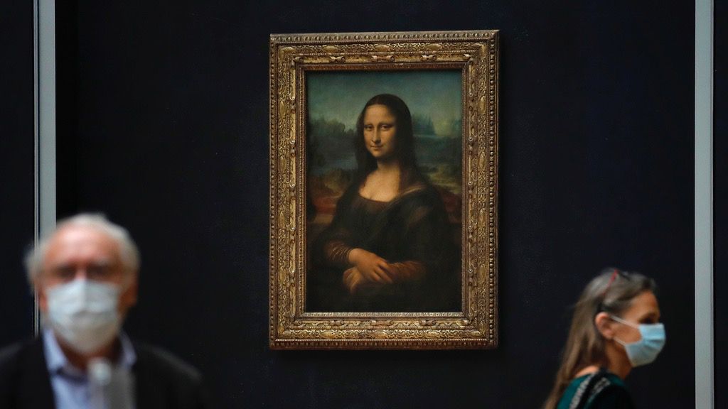 Journalists walk past Leonardo da Vinci's Mona Lisa during a visit of the Louvre museum Tuesday, June 23, 2020. (AP Photo/Christophe Ena, File)