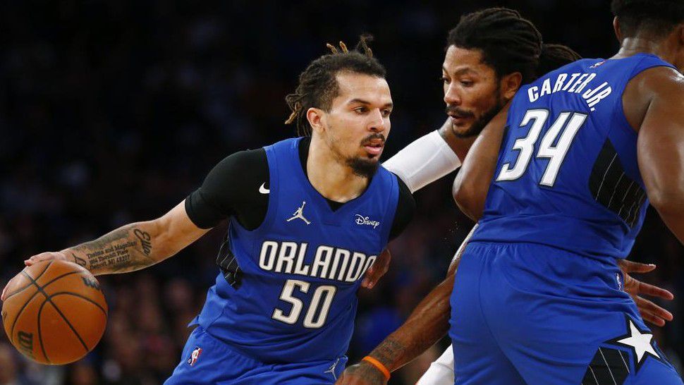 Orlando Magic's Cole Anthony (50) dribbles around teammate Wendell Carter Jr. (34) as New York Knicks' Derrick Rose (4) defends during an NBA basketball game Sunday, Oct. 24, 2021, in New York. (AP Photo/John Munson)