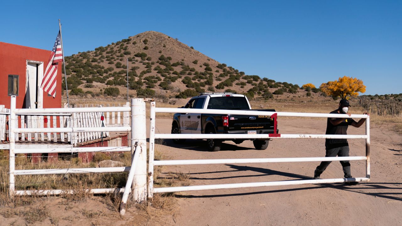 A security guard closes the gate after a Santa Fe County Sheriff's vehicle entered the Bonanza Creek Ranch in Santa Fe, N.M., Monday, Oct. 25, 2021. (AP Photo/Jae C. Hong)