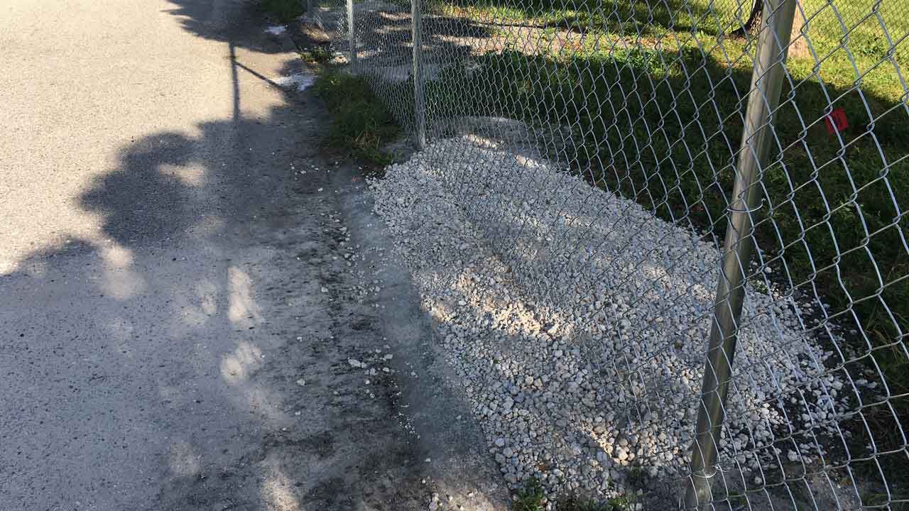 Pasco County recently installed this fence because depressions opened near the roadway on Willow Brook Ct. This is one spot that had to be filled. (Sarah Blazonis/Spectrum Bay News 9)