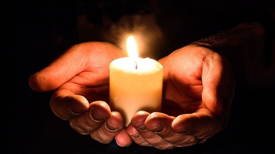 Photo of hands holding a candle (Pixabay)