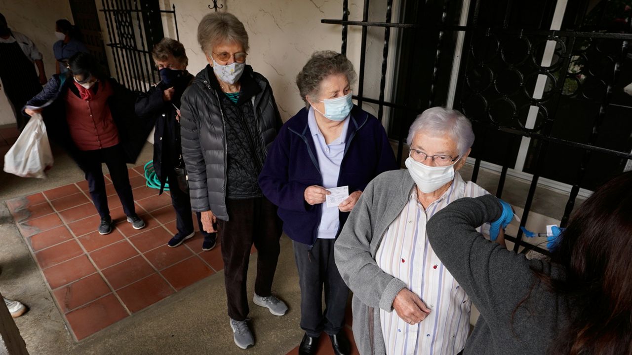 Registered nurse Liliana Ocampo, right, administers a Moderna COVID-19 vaccine to retired nuns at The Sisters of St. Joseph of Carondelet independent living center in Los Angeles Wednesday, March 3, 2021. (AP Photo/Damian Dovarganes)