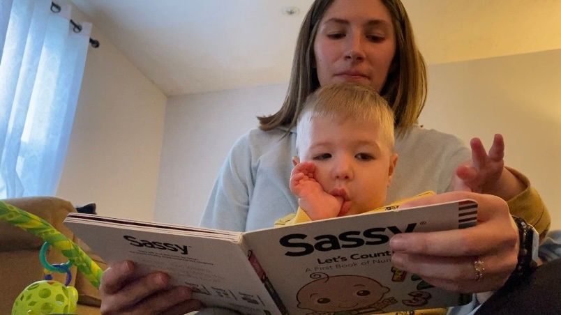 Courtney Walkenhorst reads a Dolly Parton Imagination Library book to her son, Teddy. (Spectrum News 1/Erin Wilson)