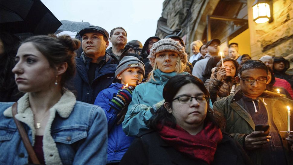 People stand on the stairs of Sixth Presbyterian Church as the crowd spills up the hill and down the street for a vigil blocks from where an active shooter shot multiple people at Tree of Life Congregation synagogue on Saturday, Oct. 27, 2018, in the Squirrel Hill section of Pittsburgh. (Stephanie Strasburg/Pittsburgh Post-Gazette via AP)
