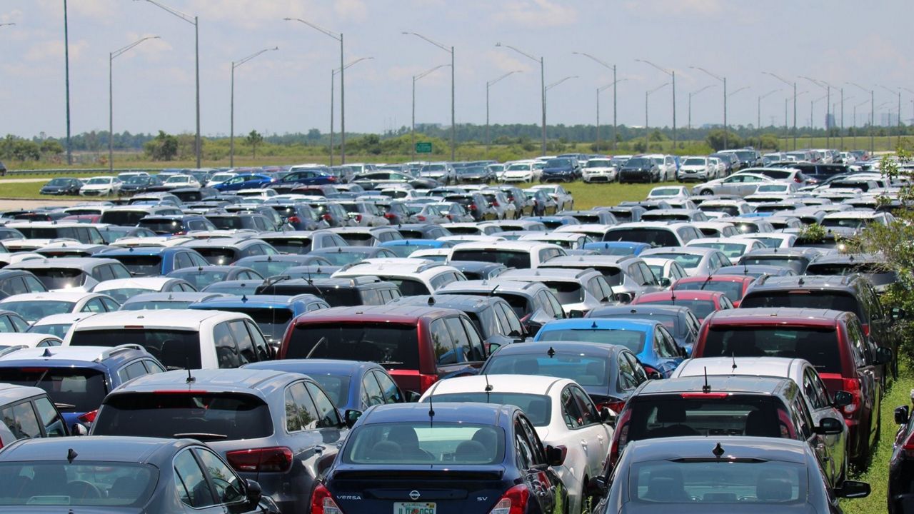 In this file photo from May 30, 2020, rental cars sit idle in a grass lot on Orlando International Airport property. Rental car companies pulled inventory when demand plunged at the start of the pandemic. (Greg Angel/Spectrum News)