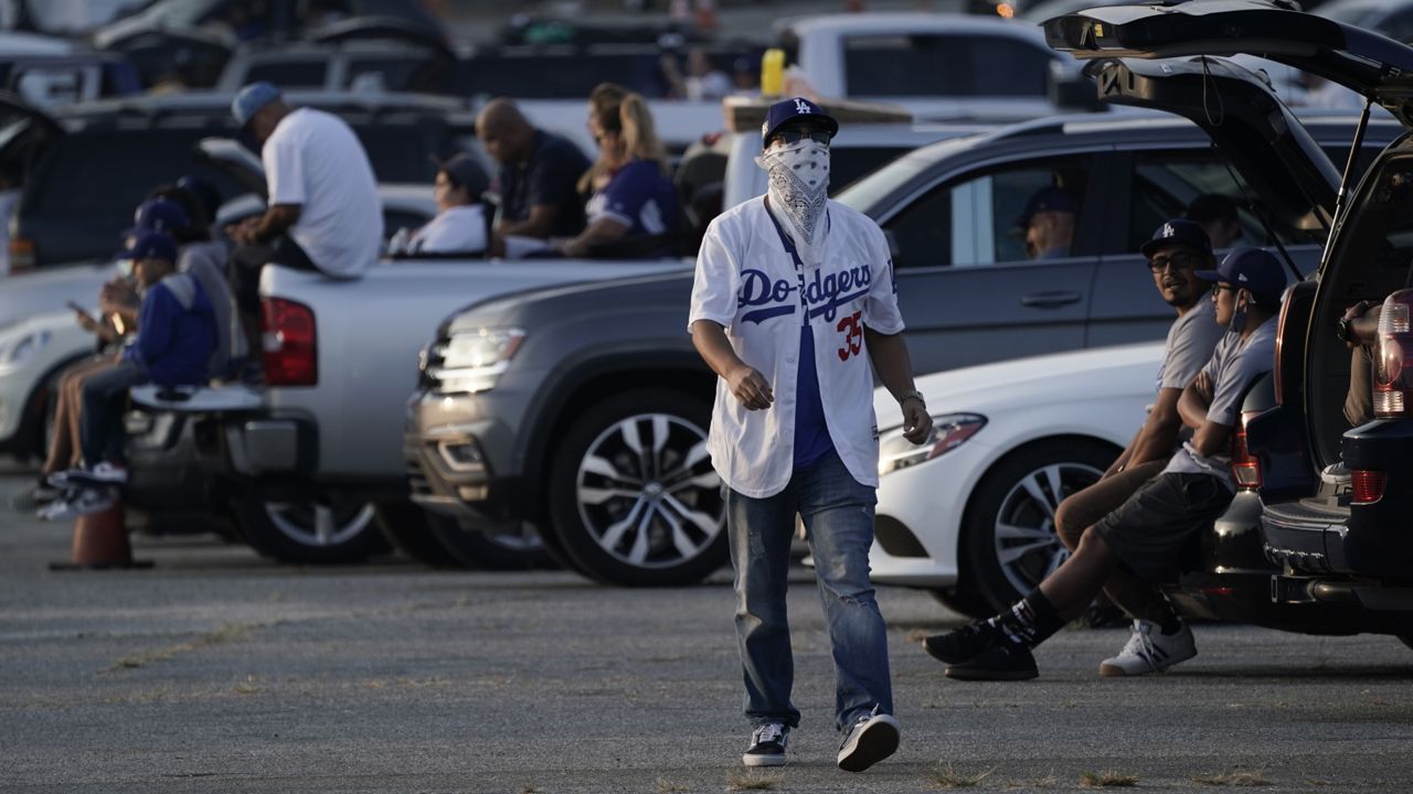 Fans sit in their cars outside of Dodger Stadium in Los Angeles to watch the television broadcast of Game 1 of the World Series between the Los Angeles Dodgers and the Tampa Bay Rays on Oct. 20, 2020. (AP Photo/Ashley Landis)