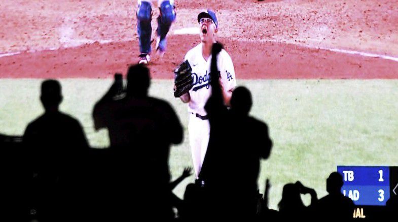 Julio Urias of the Los Angeles Dodgers reacts after the last out as fans celebrate from their cars as they watch the national broadcast of the Los Angeles Dodgers defeat the Tampa Bay Rays 3-1 during game 6 to win the the 2020 MLB World Series baseball game in the parking lot at Dodger Stadium in Los Angeles on Tuesday, October 27, 2020. (Keith Birmingham/The Orange County Register via AP)