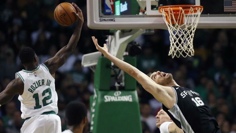 Boston Celtics' Terry Rozier (12) grabs a rebound behind San Antonio Spurs' Pau Gasol (16) during the third quarter of an NBA basketball game in Boston, Monday, Oct. 30, 2017. The Celtics won 108-94. (AP Photo/Michael Dwyer)